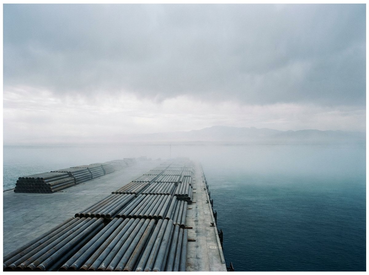 Filas de tubería de acero en el muelle de un puerto de desierto.